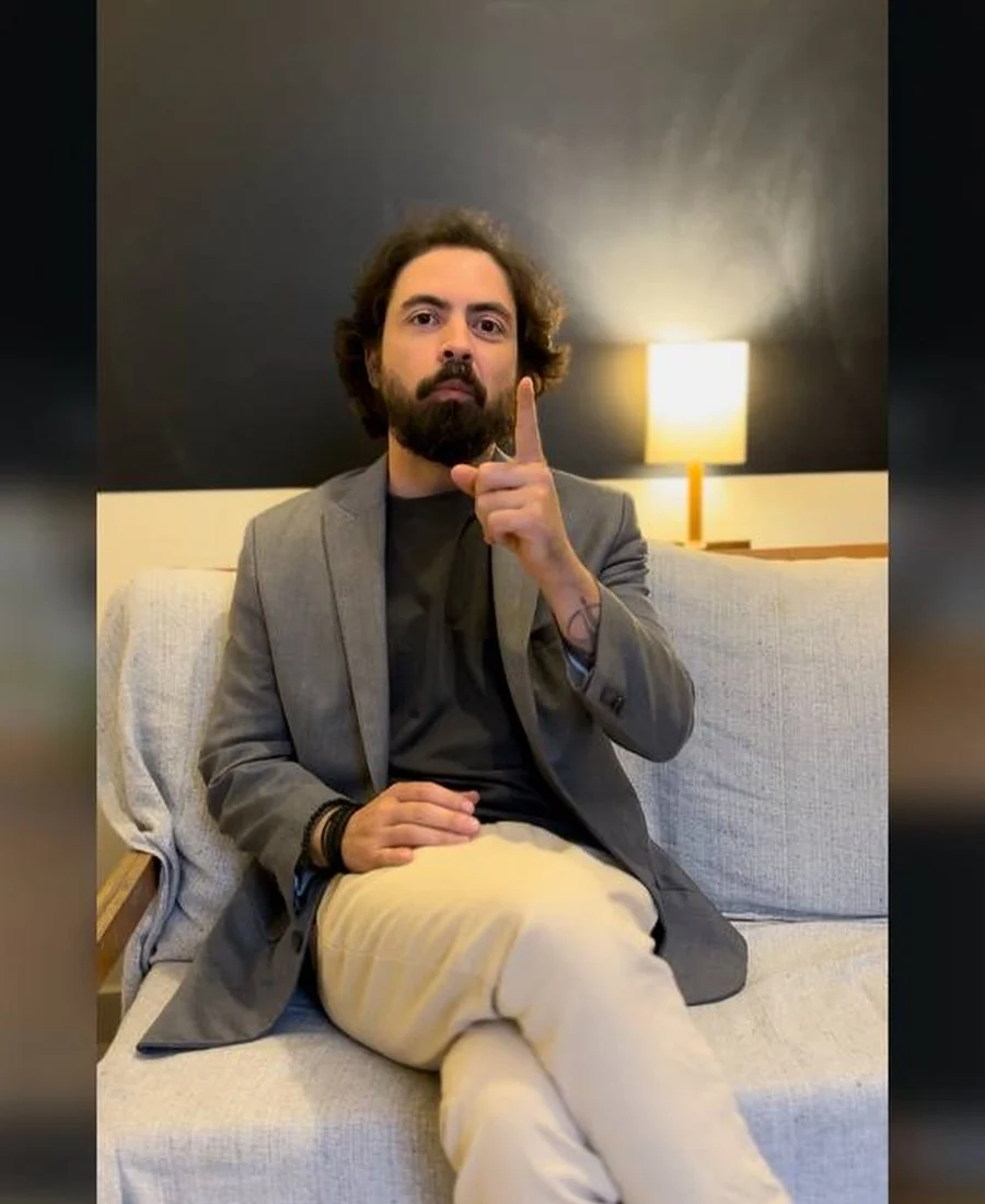 Daniel Hausch em uma conversa, usando blazer cinza